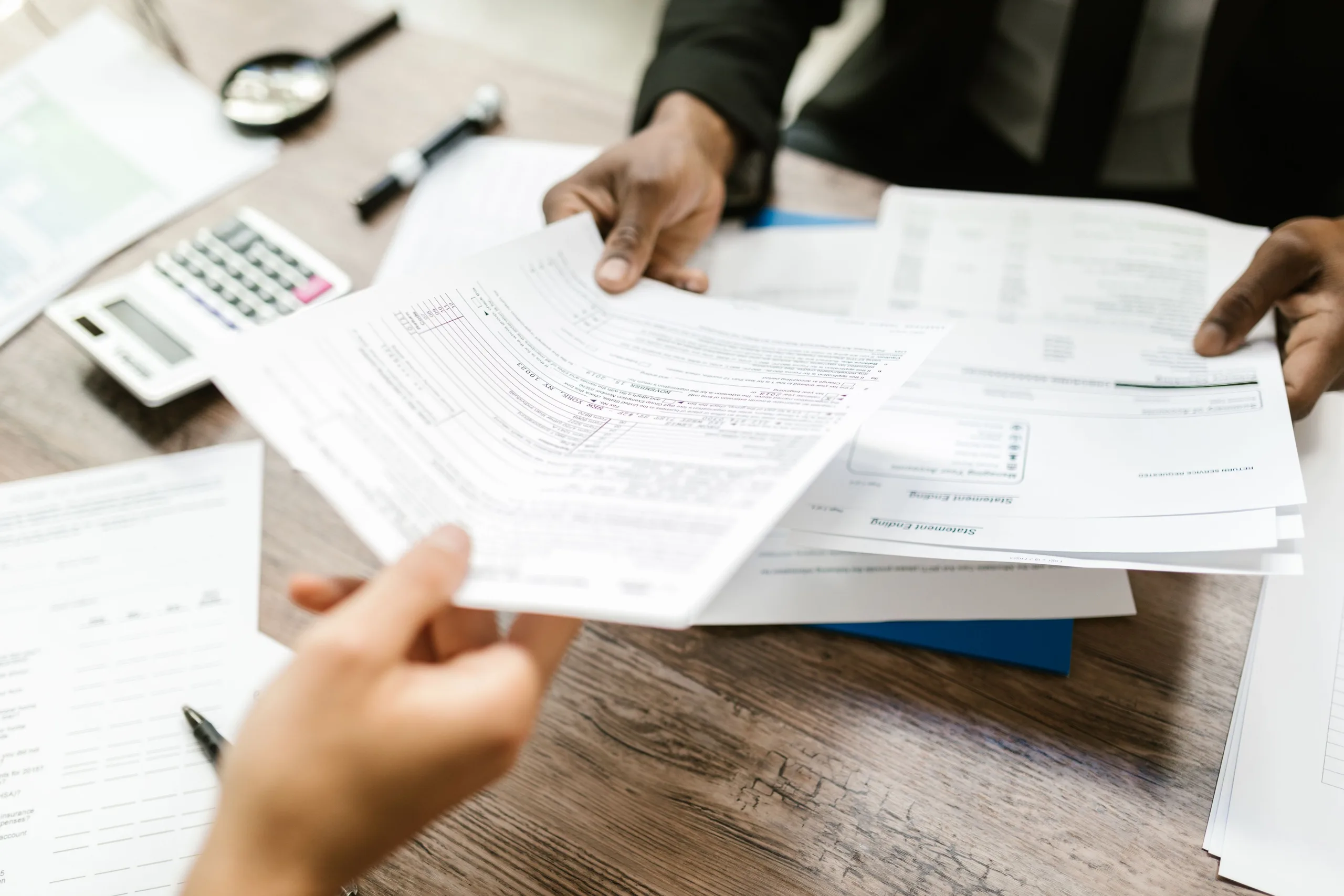 Deux professionnels échangeant des documents dans un cadre professionnel.