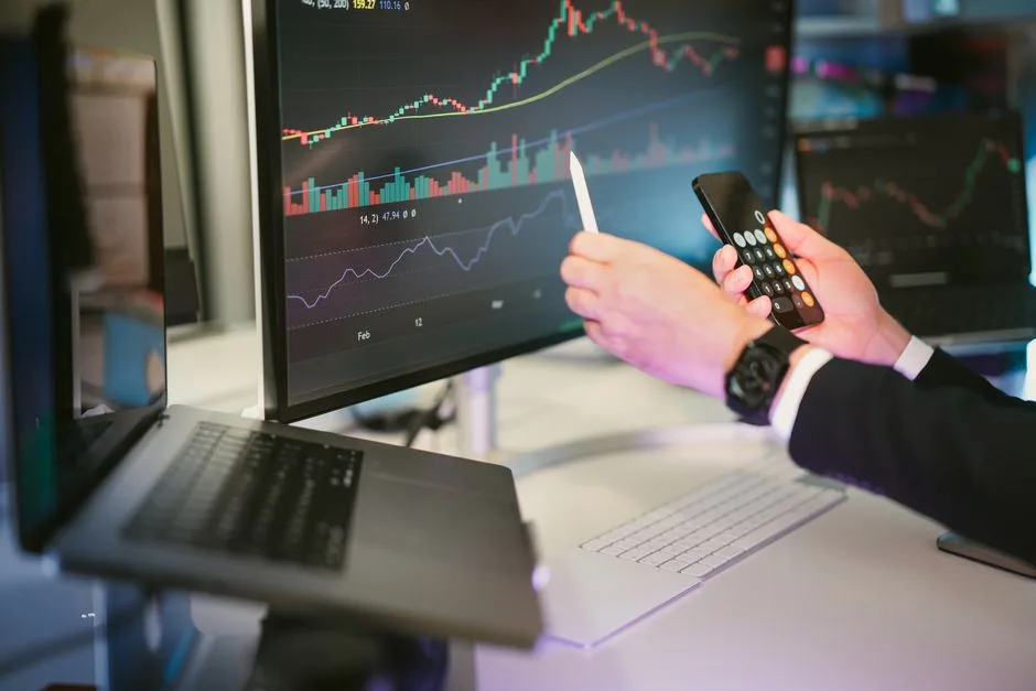 Des professionnels des affaires analysent les données de la bourse sur un smartphone dans un cadre de bureau.
